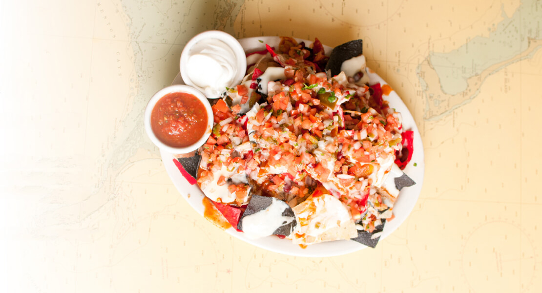 plate with nachos and dipping sauces